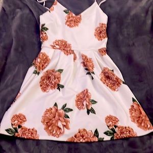 This is a stunnig white dress with rosey flowers on it and is a size Large.